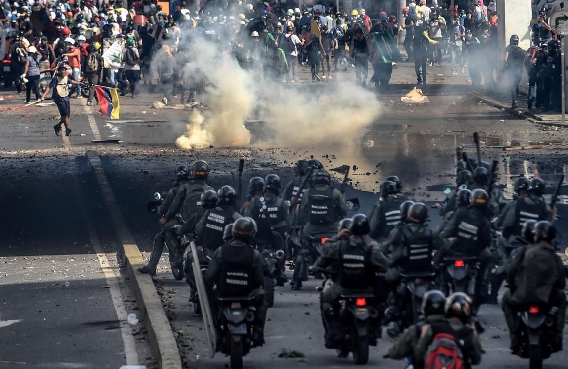 Riot police officers confront opposition activists